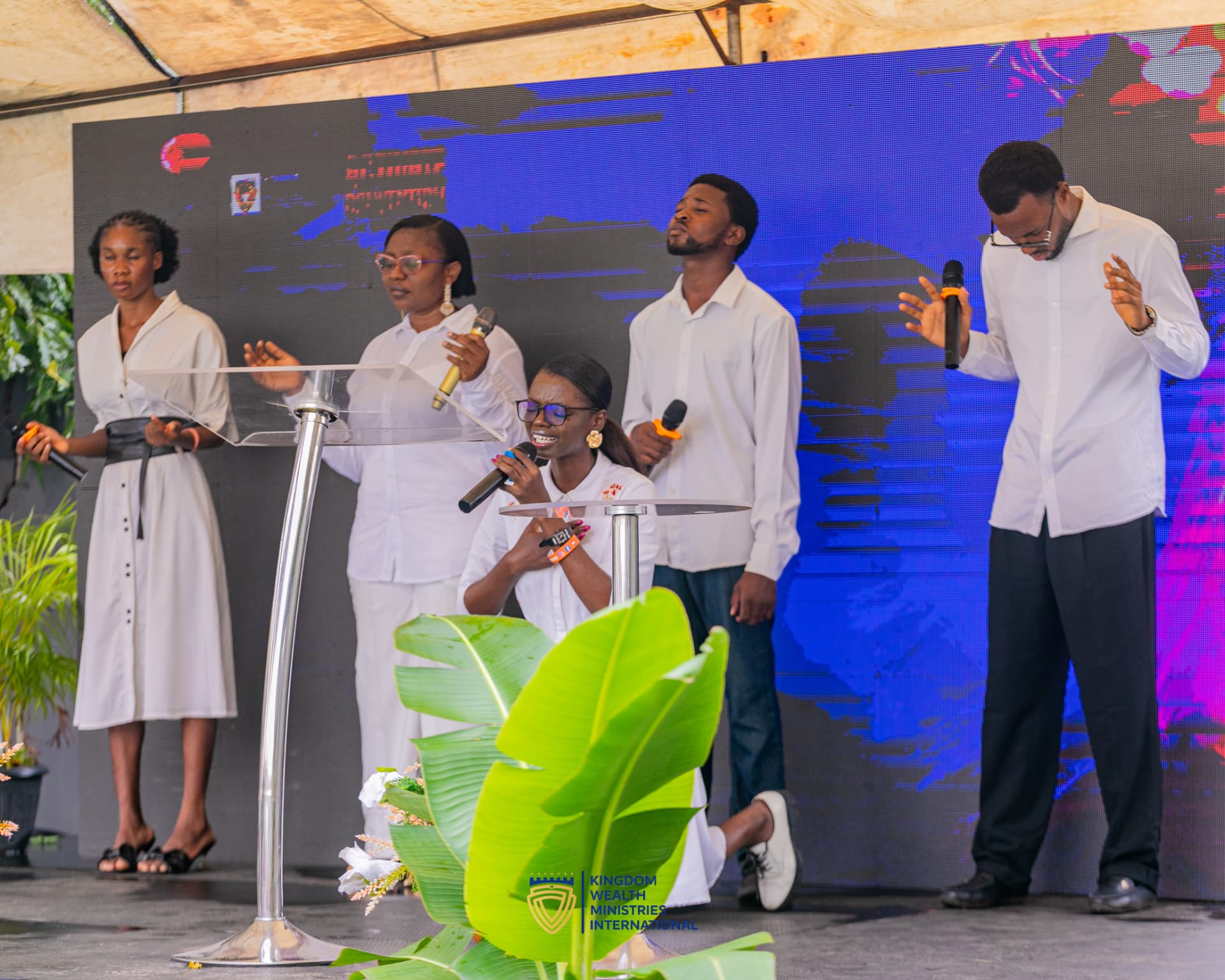 The KWMI worship team ministering on stage in white